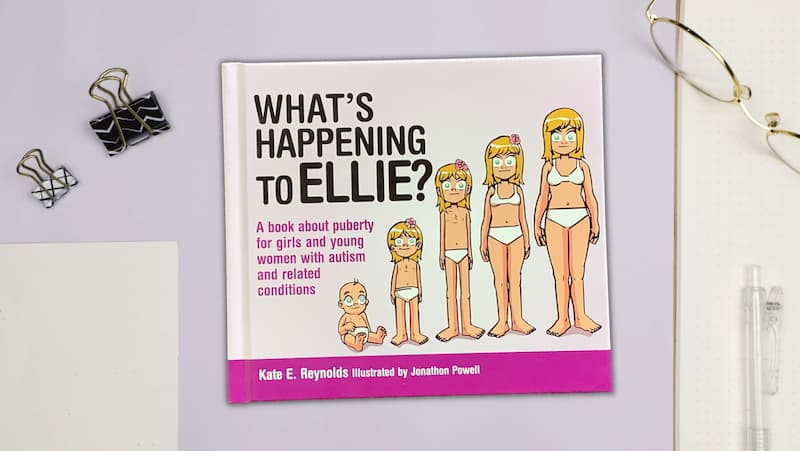 a book titled 'what's happening to ellie?' sits on a desktop next to a pair of reading glasses, paper and assorted stationery